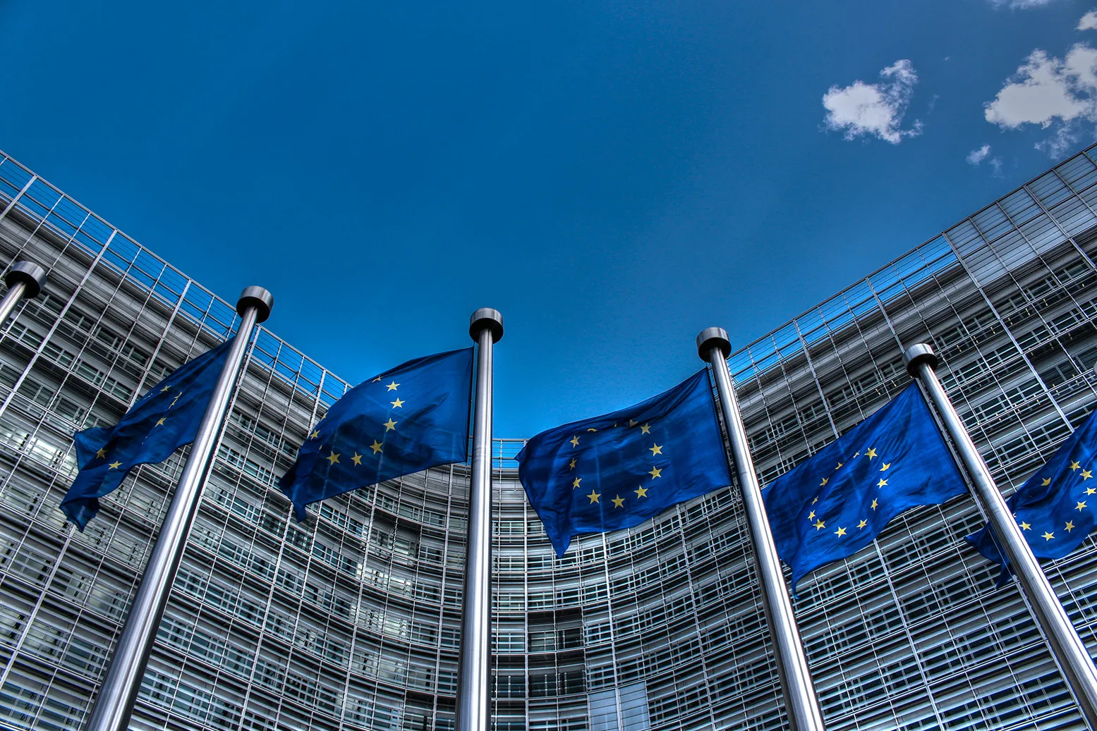 EU flags outside a curved glass institutional building