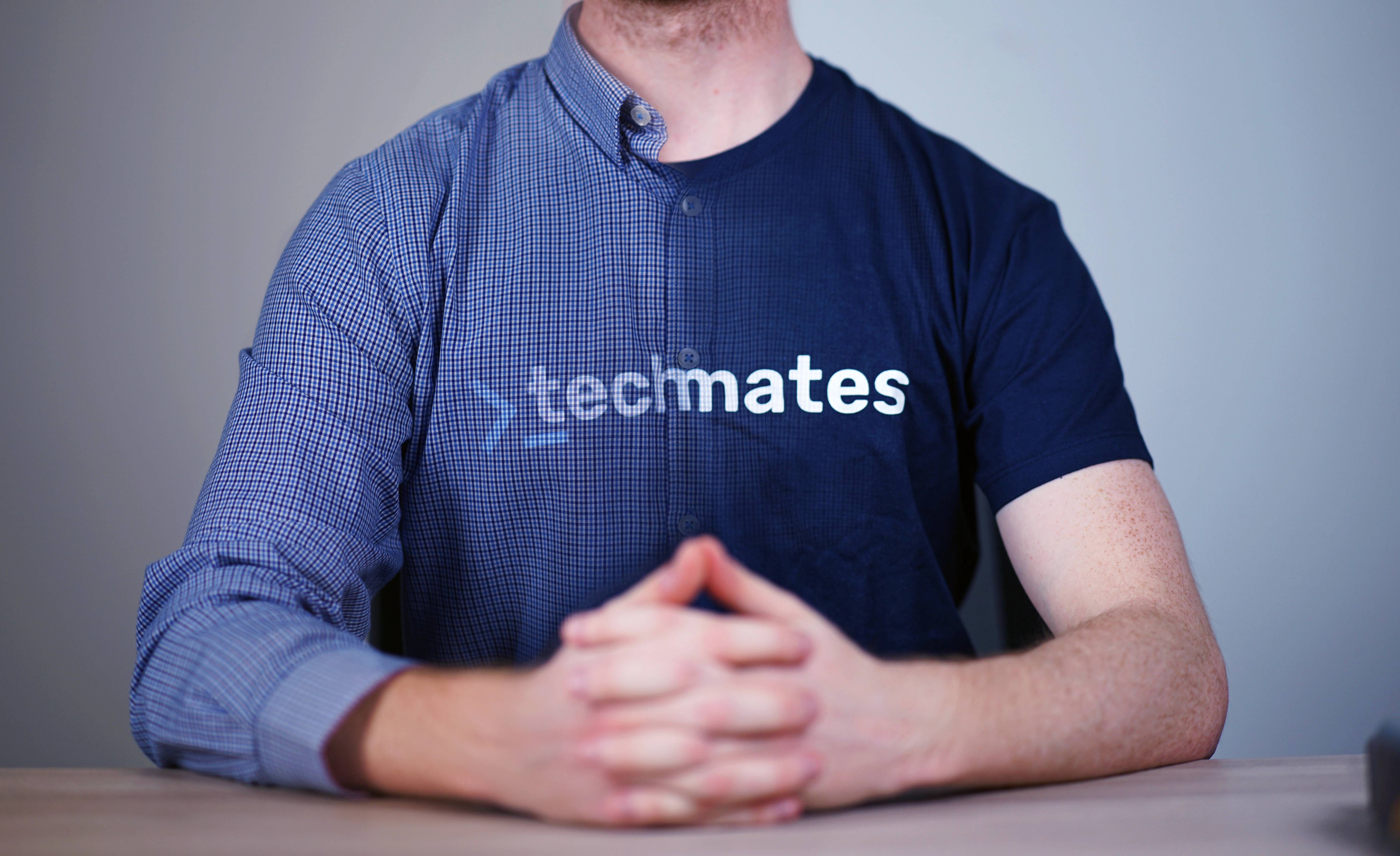 Seated person wearing a shirt with the Techmates logo