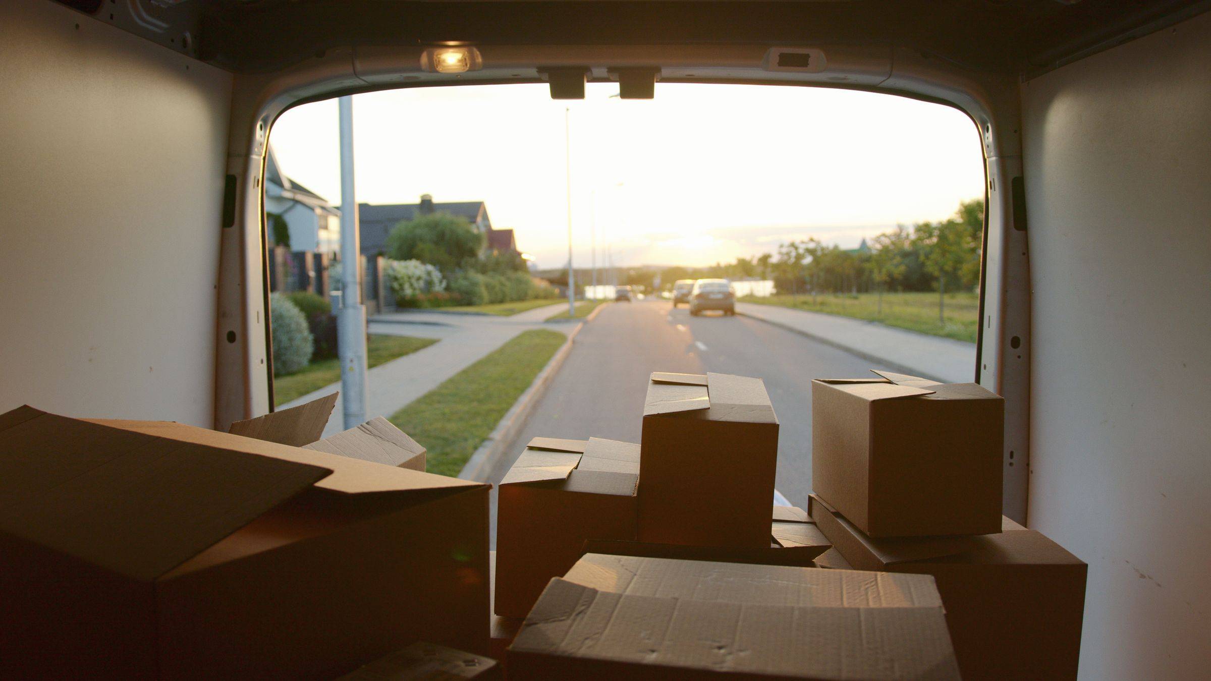 Delivery parcels stacked by the open door of a van