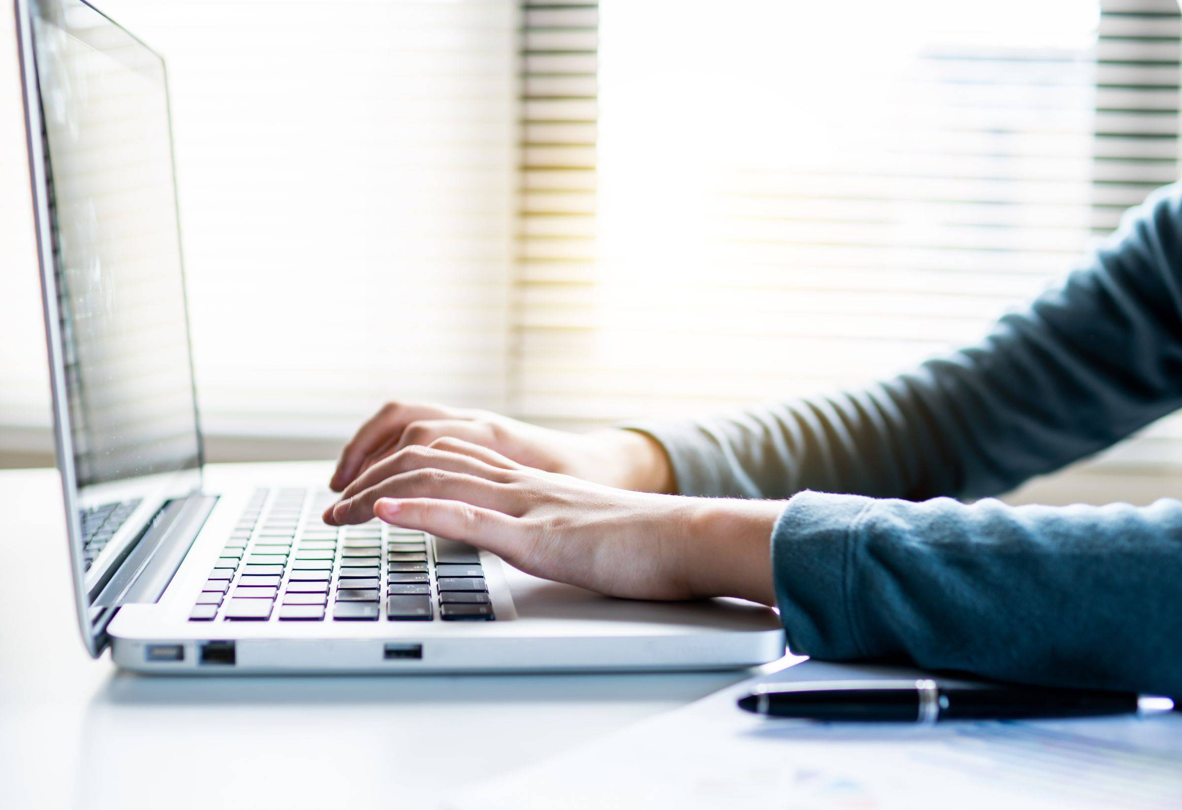 Hands typing a search on a laptop