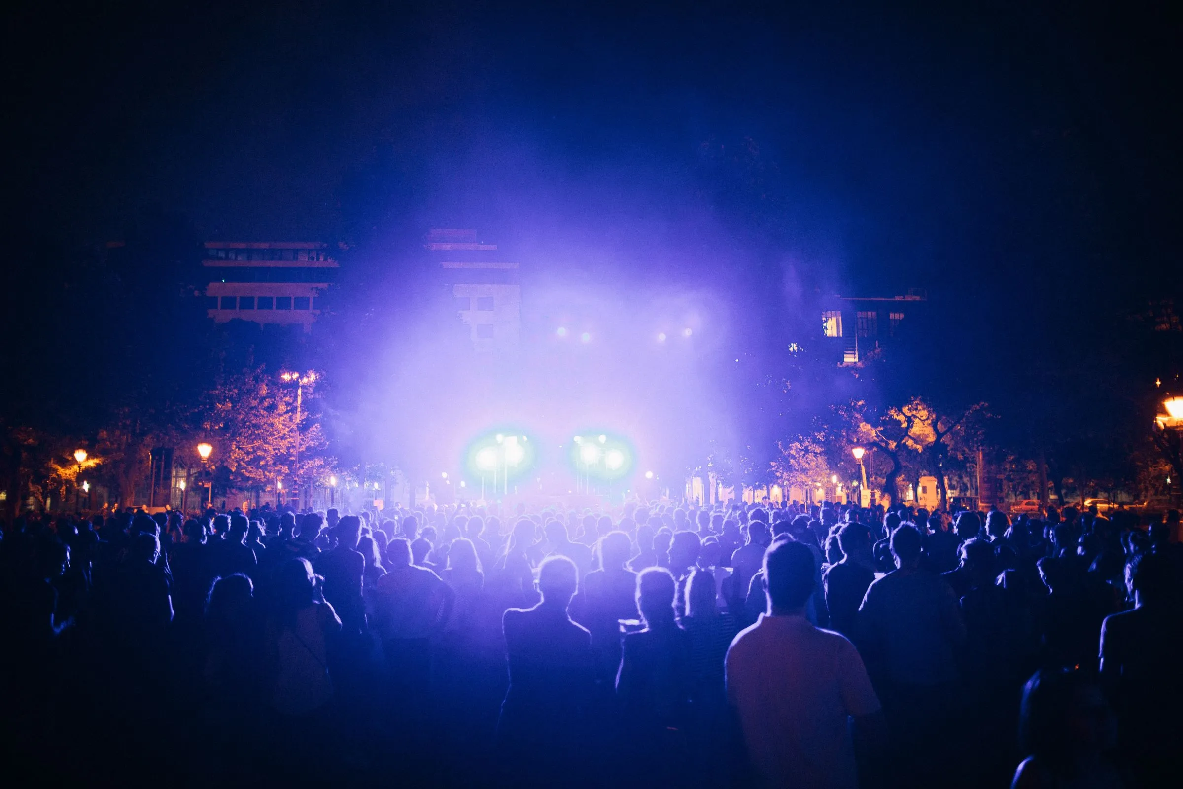 Festivalový dav pod světly pódia za soumraku